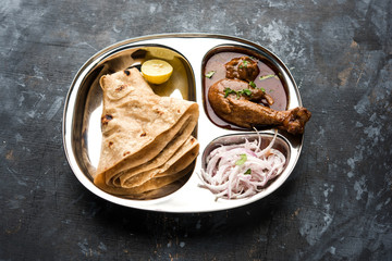 Mini chicken curry Thali with chapati/roti, popular indian lunch/dinner menu. served in a stainless...