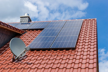 red tiled roof with solar panesl or photovoltaic plant and satellite dish
