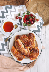 Homemade baked croissant with fresh garden cherries
