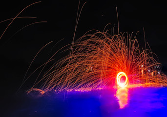 Fire show. Amazing fire performance in the night. Abstract fife sparks background. Long-exposure photography captures the trails created by sparks