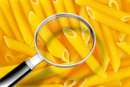 Quality control about Italian pasta - HACCP (Hazard Analyses and Critical Control Points) concept image with Italian pasta seen through the magnifying glass