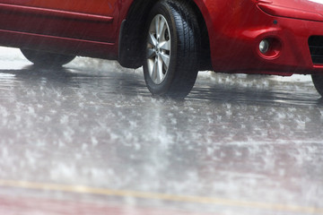 Summer shower. Car wheels in the summer rain