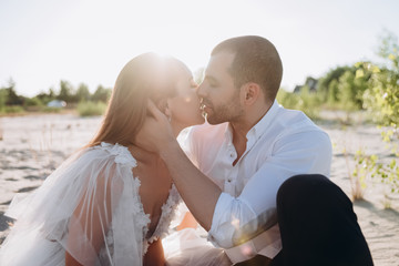 Obraz premium beautiful happy couple kissing on beach with back light
