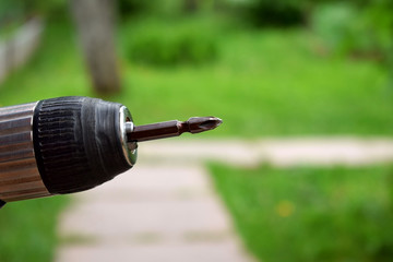 Close-up of a drill against the garden