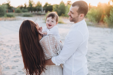 Fototapeta premium happy family with baby boy on beach together