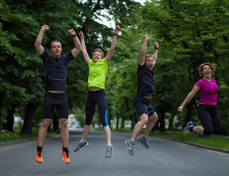 runners team jumping in the air during  morning training