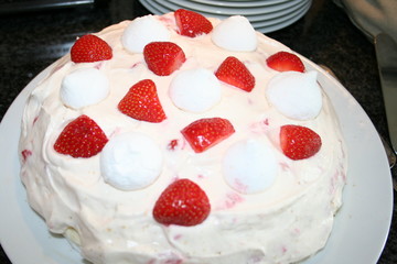 Delicious cake with meringue, lemon, cream and decoration with strawberries in pieces