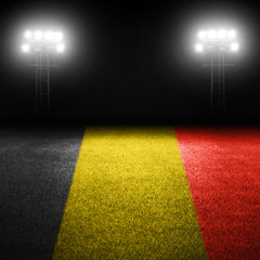 Fototapeta na wymiar Belgian flag field with illuminated stadium lights in background