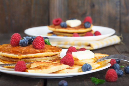 Sweet american breakfast. Buttermilk pancakes served hot with maple syrup and fresh berry fruit .