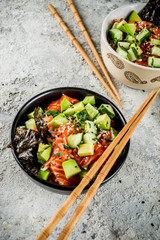 Asian trendy food, sushi poke bowl with cucumber, salmon, avocado, Black and White Sesame Seeds