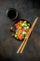Asian trendy food, sushi poke bowl with cucumber, salmon, avocado, Black and White Sesame Seeds