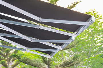 black canvas with steel machanic structure awning on tree background - obrazy, fototapety, plakaty