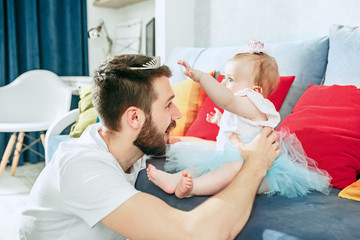 Proud father holding his baby daughter at home
