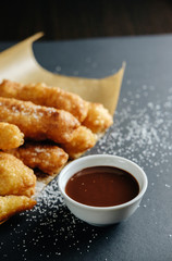 small homemade pies on black background cup with chocolate bakery paper scattered sugar on the table
