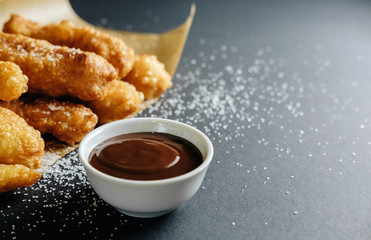 small homemade pies on black background cup with chocolate bakery paper scattered sugar on the table