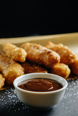 small homemade pies on black background cup with chocolate bakery paper scattered sugar on the table