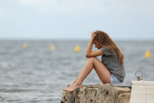Sad teen alone with ocean in the background