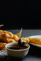 small homemade pies on black background cup with chocolate bakery paper scattered sugar on the table