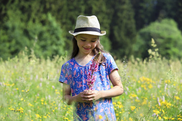 Ein Mädchen steht in einer wilden Blumenwiese im Thüringer Wald