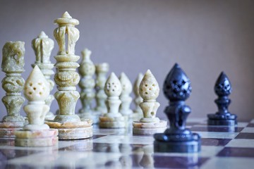  Close-up of black and white soapstone marble chess pieces on chessboard     