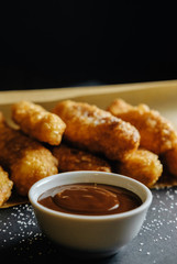 small homemade pies on black background cup with chocolate bakery paper scattered sugar on the table
