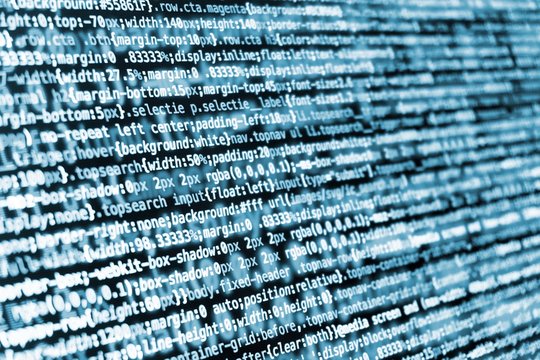 Compressed CSS programming code on screen in blue tones