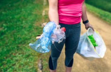 Plogging concept. Detail of unrecognizable girl showing the garbage she has collected. Selective...