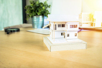 Scale model of new home design with 3D mockup on table.  Home construction.
