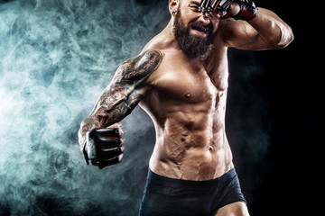 Sportsman boxer fighting on black background with smoke. Copy Space. Boxing sport concept.