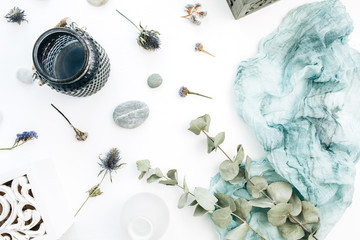 Festive holiday composition with space for text of blue blanket, flowerpot, flowers and eucalyptus branches on white background. Flat lay, top view wedding concept.