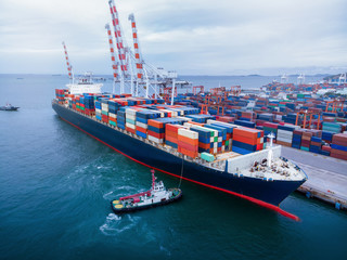 Cargo container ship in the cargo international yard port carrying full load ready to export .
