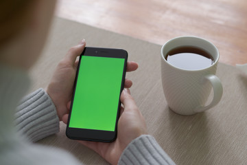 Close up of women's hands holding cell telephone with blank copy space screen for your advertising text message or promotional content.