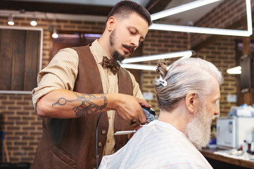 Stylish beard. Profile photo of mature client that sitting in semi position while looking at himself