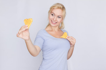 Happy blond woman holding in hands and showing belgian waffles