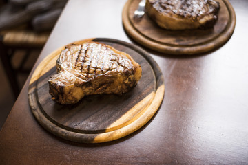 adult beef steak served on a wooden chopping board