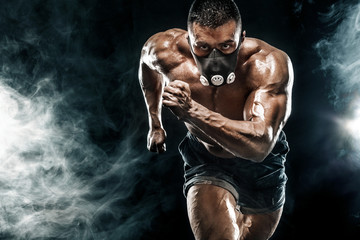 Strong athletic man sprinter in training mask, running, fitness and sport motivation. Runner...