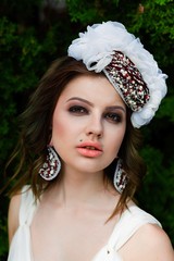 portrait of young sensual woman posing in elegant headwear