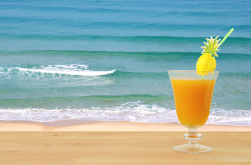 image of tropical and exotic fruit coctail over wooden table infront of sea landscape background.