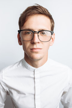 Portrait of young attractive guy in glasses, in white shirt, isolated on white background, for advertising, text insertion