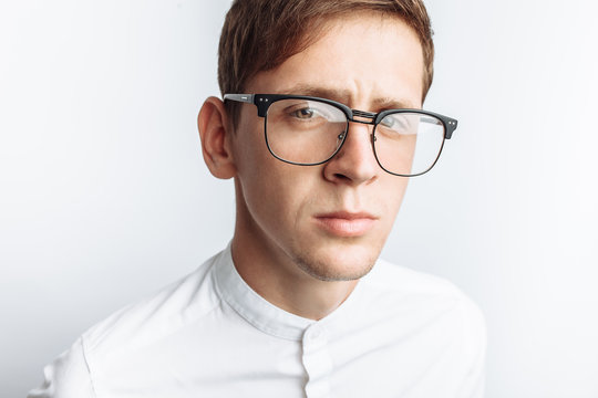 Portrait of young attractive guy in glasses, in white shirt, isolated on white background, for advertising, text insertion
