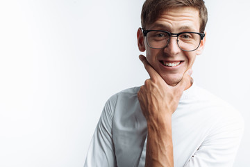 Portrait of young attractive guy in glasses depicting joy, in white shirt isolated on white background, for advertising, text insertion - obrazy, fototapety, plakaty