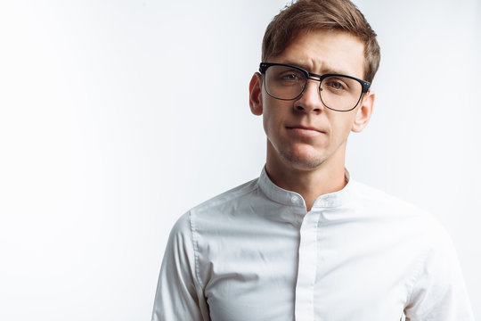 Portrait of young attractive guy in glasses, in white shirt, isolated on white background, for advertising, text insertion