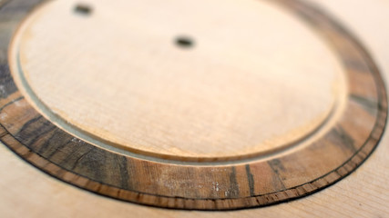 The guitar master installs  rosette in a classical guitar.