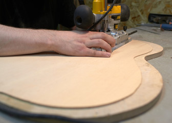 The guitar master marks and cuts the grooves to install the rosette in a classical guitar.