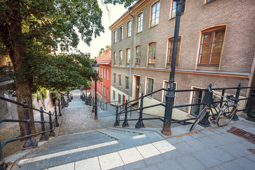 Old street with bicycle and stairs between historical houses in Stockholm, Sweden.