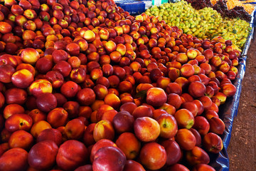 Peaches and nectarines on the counter are sold at the grocery store.