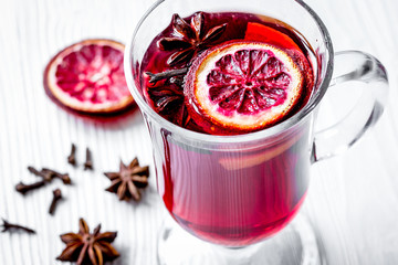 mulled wine with spices in cup on wooden background