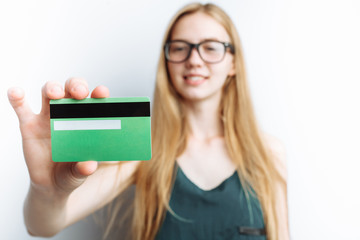 Beautiful girl shows Bank card, blurred background, white background, advertising card