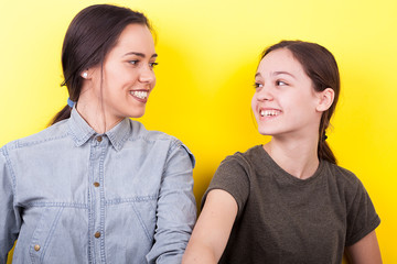 Best girlfriends in studio photo on yellow background