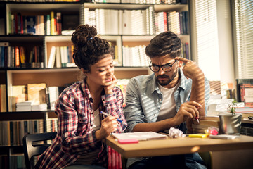 Two young students are having a problem while solving difficult school task they have and are brainstorming new ideas on how to realize it.